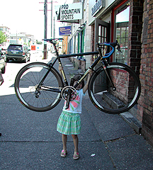 Grace Towle, 6, holds a bike above her head